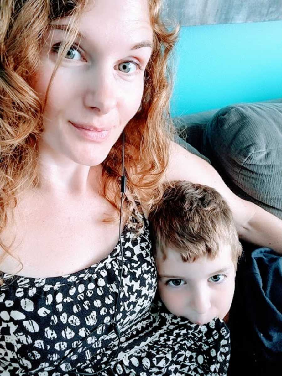 A neurodivergent woman sits on a couch with her son