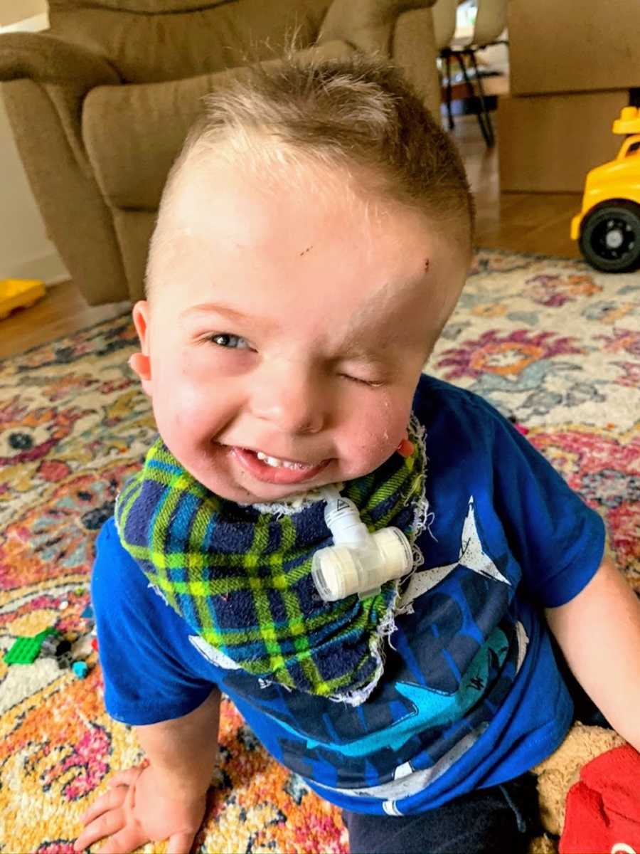 Baby boy wearing blue shirt smiling at camera