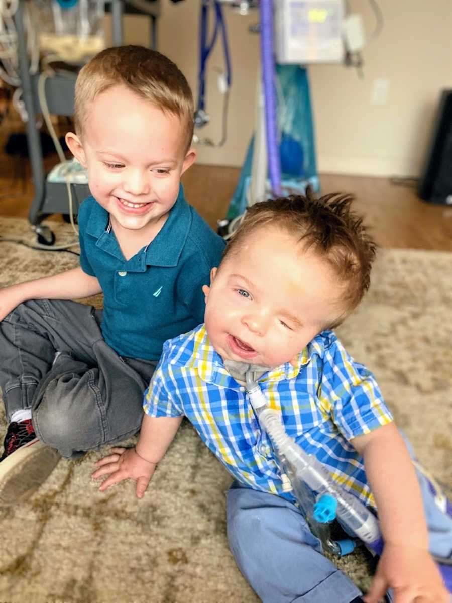 Brothers sitting on floor wearing blue