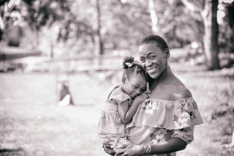 一位母亲在公园里抱着她的小女儿