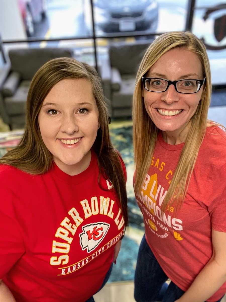 Two women wearing Kansas City football shirts smiling