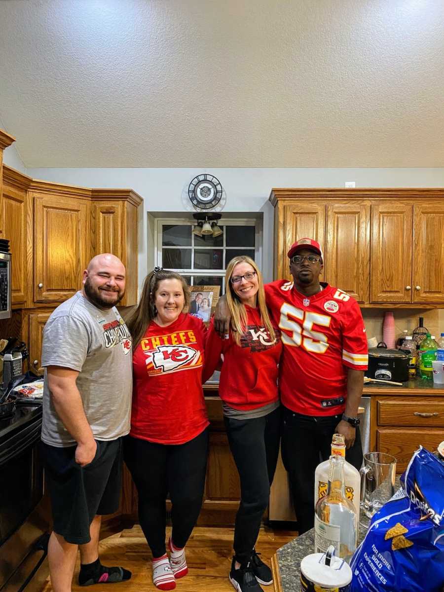 Four parents taking picture in kitchen