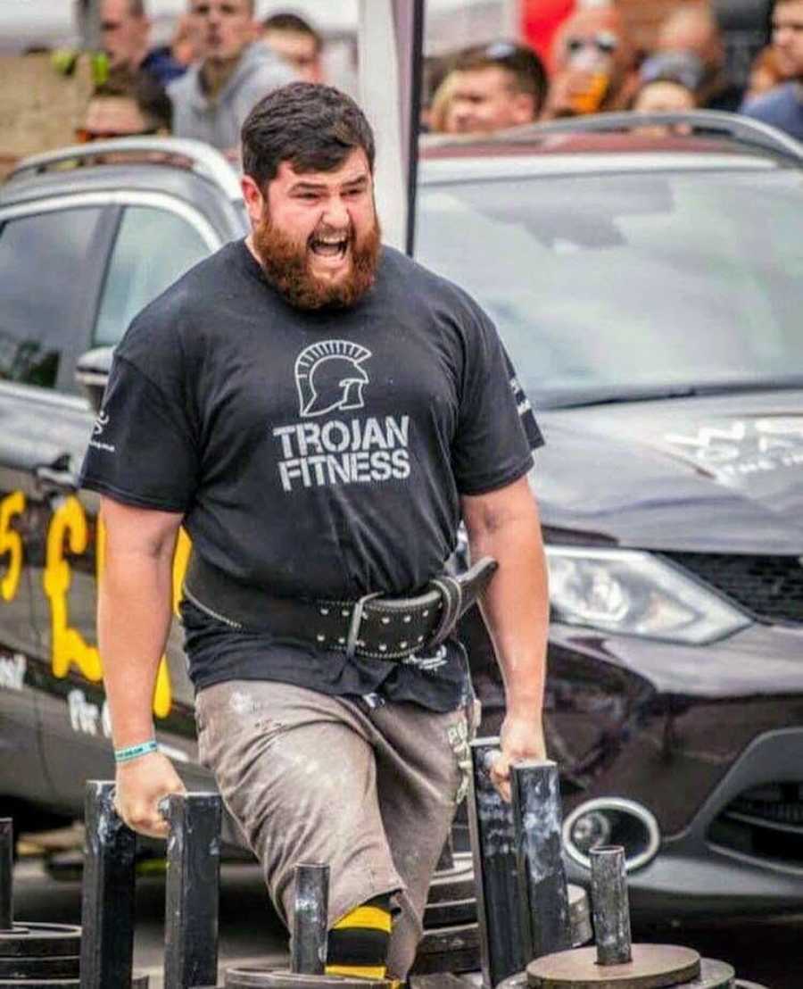 Man at fitness competition holding weights and walking