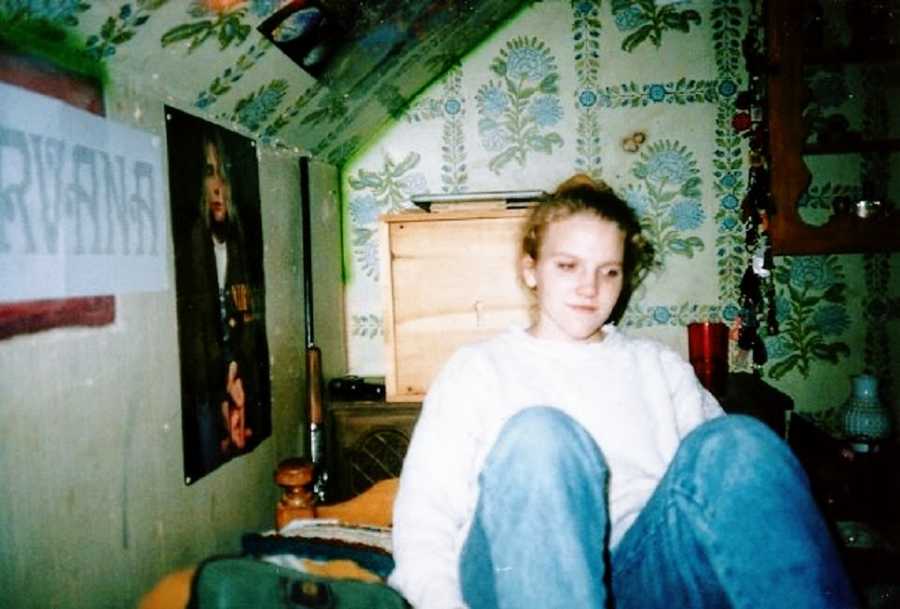 A young woman with undiagnosed autism sits in a wallpapered room