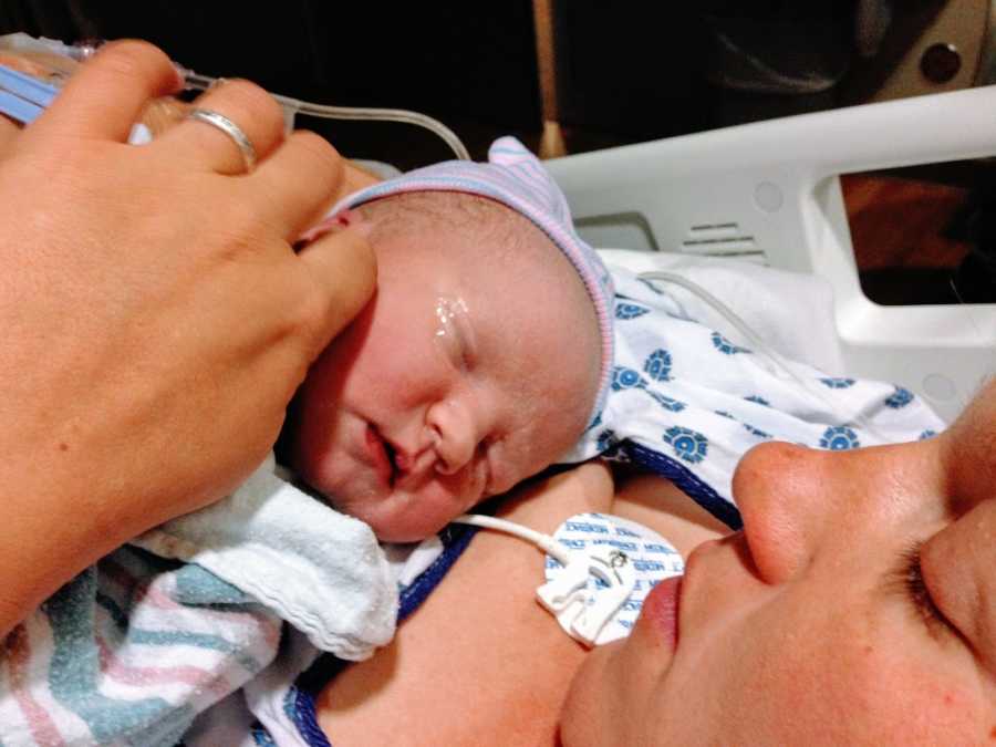 A mother with autism holds her newborn son to her chest in the hospital