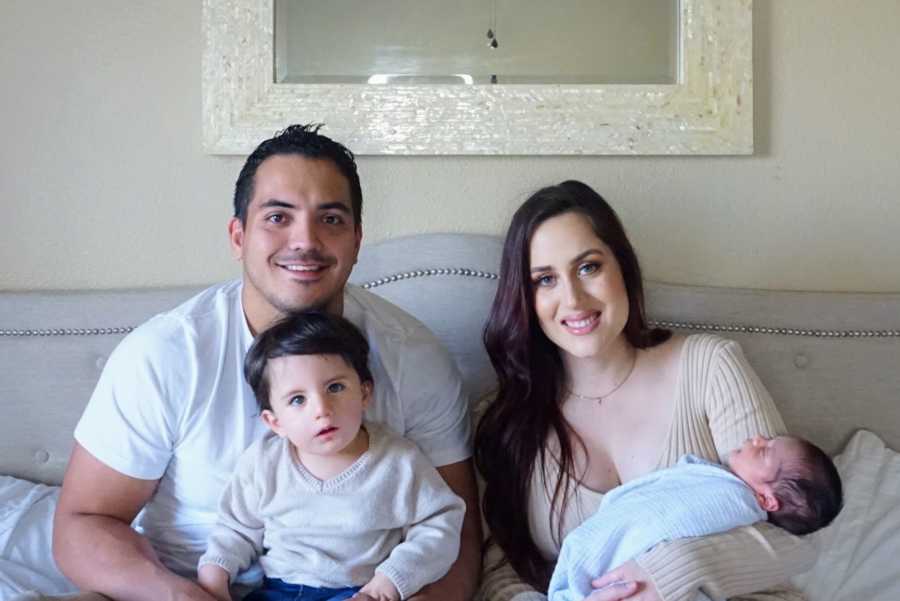 Family of four sitting in bed 