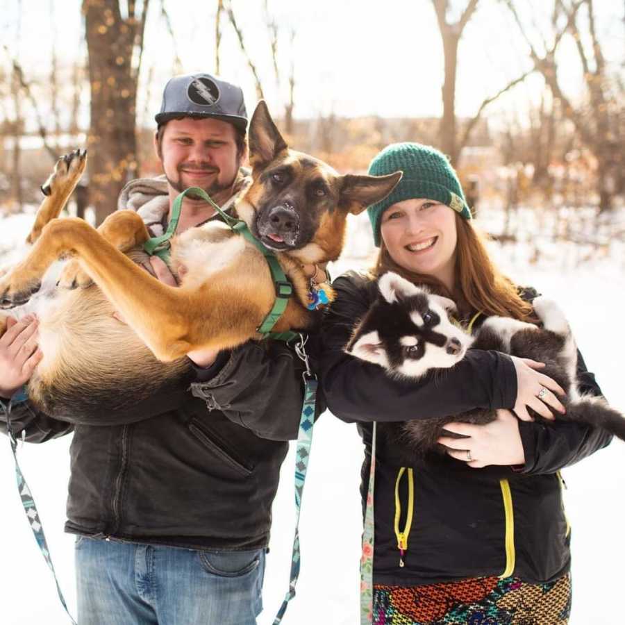 Couple taking photo holding dogs outside in winter