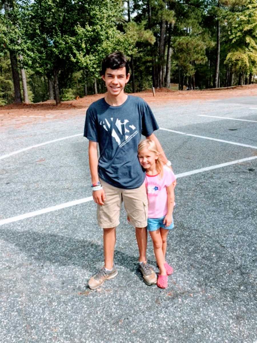 An adopted boy from Ukraine and his young sister stand outside