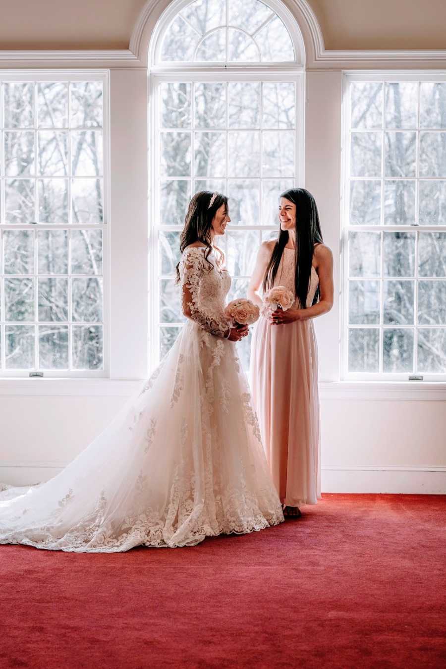 A woman and her adopted sister stand together at her wedding