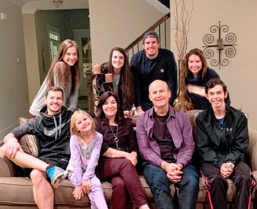 A family including three adopted children sits on a couch