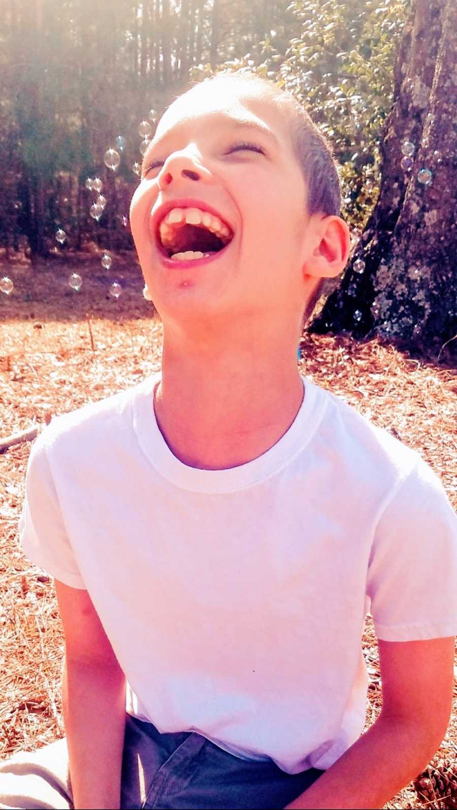 A boy with a rare chromosome disorder laughing