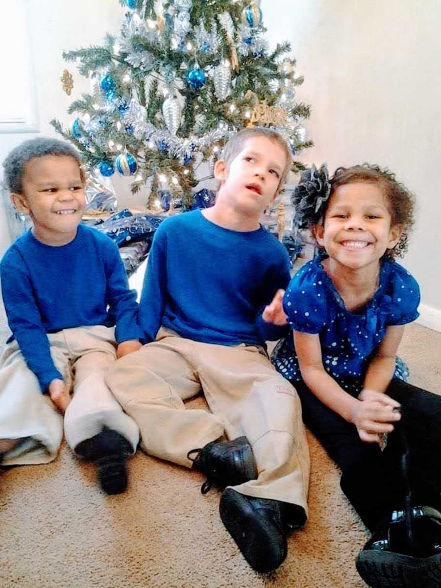 A boy with a rare chromosome disorder sits next to his siblings at Christmas