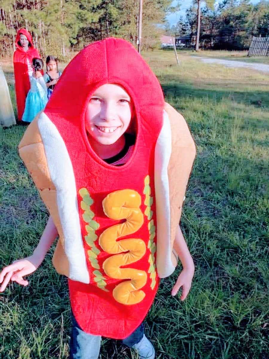 A boy with a rare chromosome disorder wearing a hotdog costume