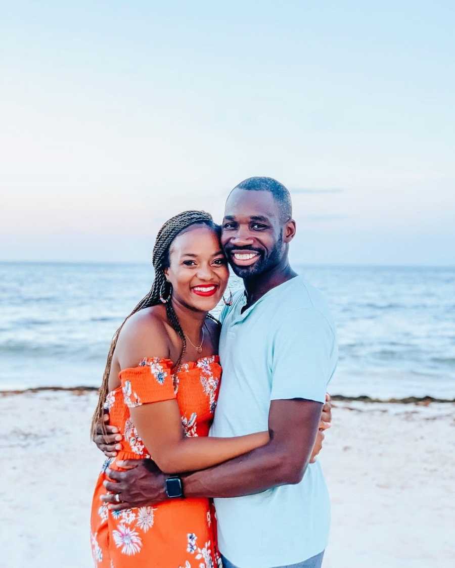 A woman and her husband hold each other on a beach