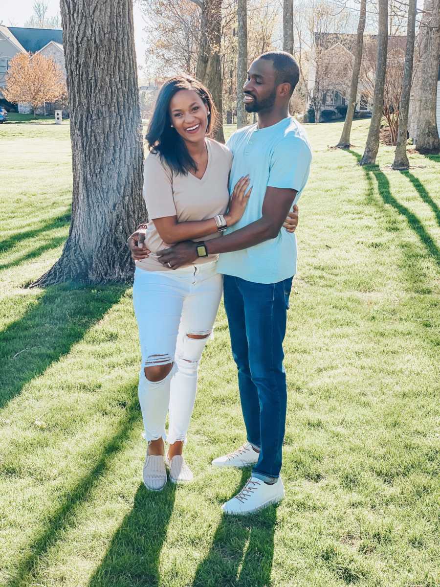 Husband and wife with arms around each other standing outside