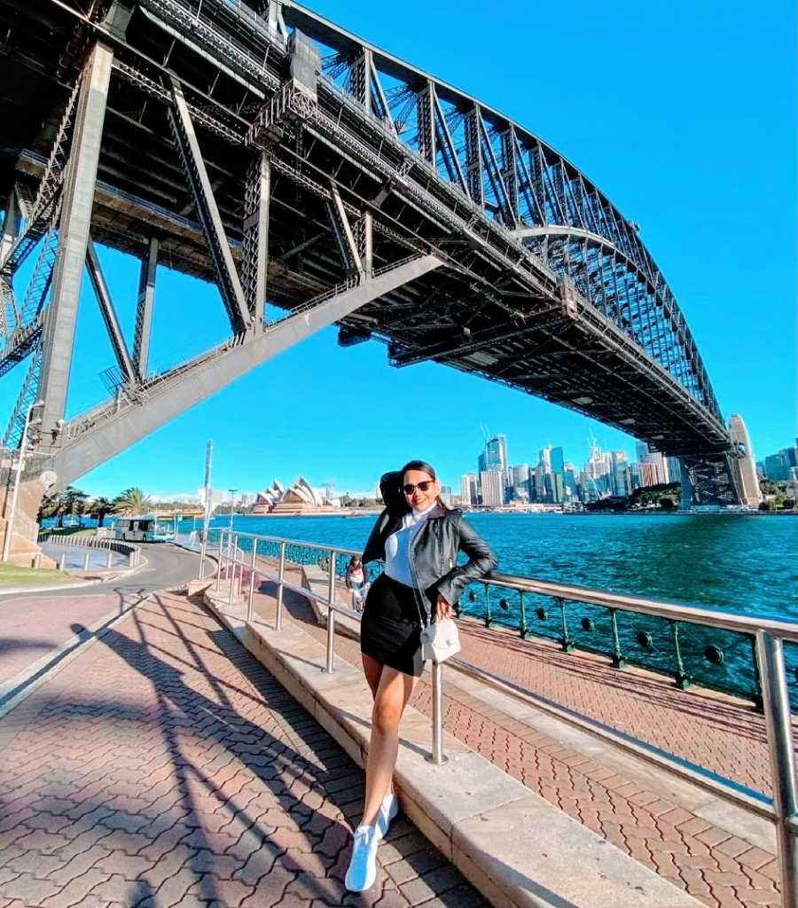 A single mother with alopecia stands by a bridge