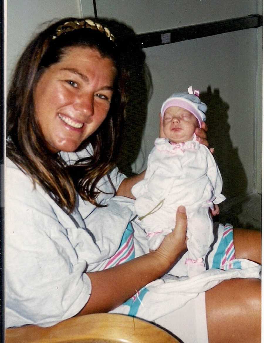 New mom holding up newborn, premature baby daughter