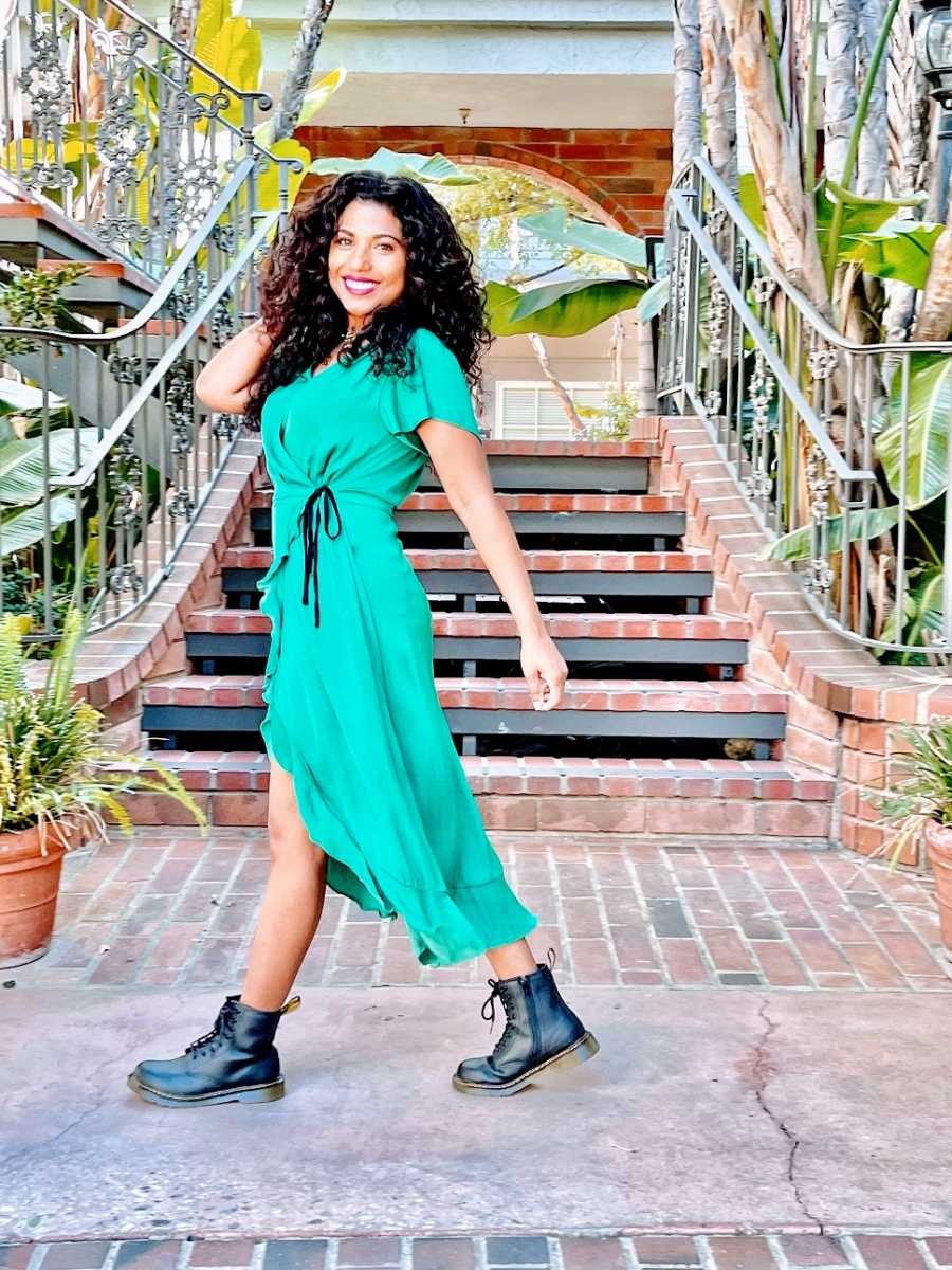 A mom with curly dark hair wears a bright green dress