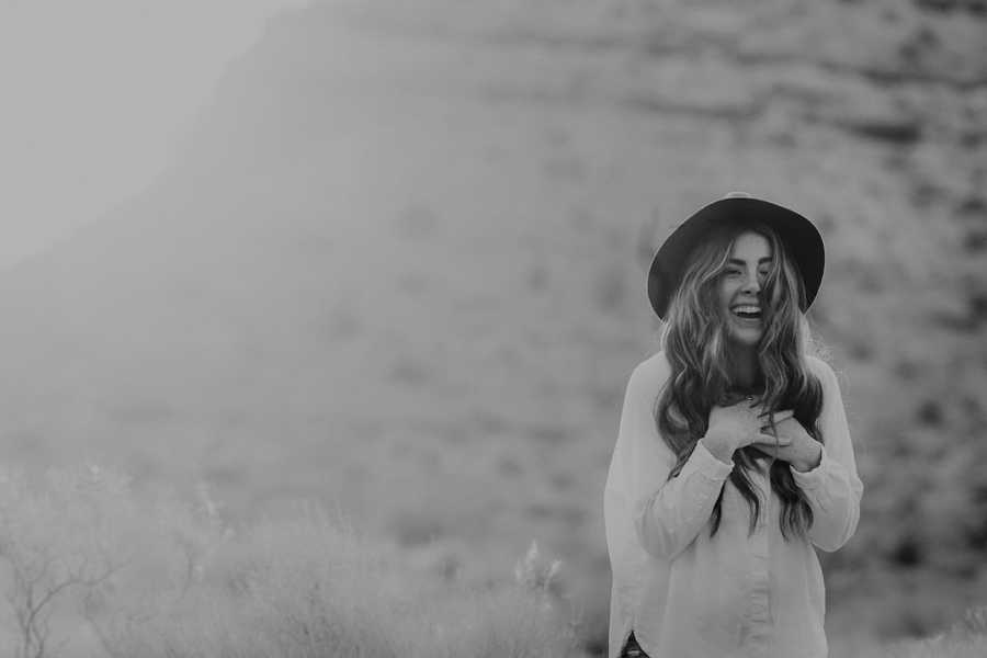 Black and white photo of woman wearing hat and laughing