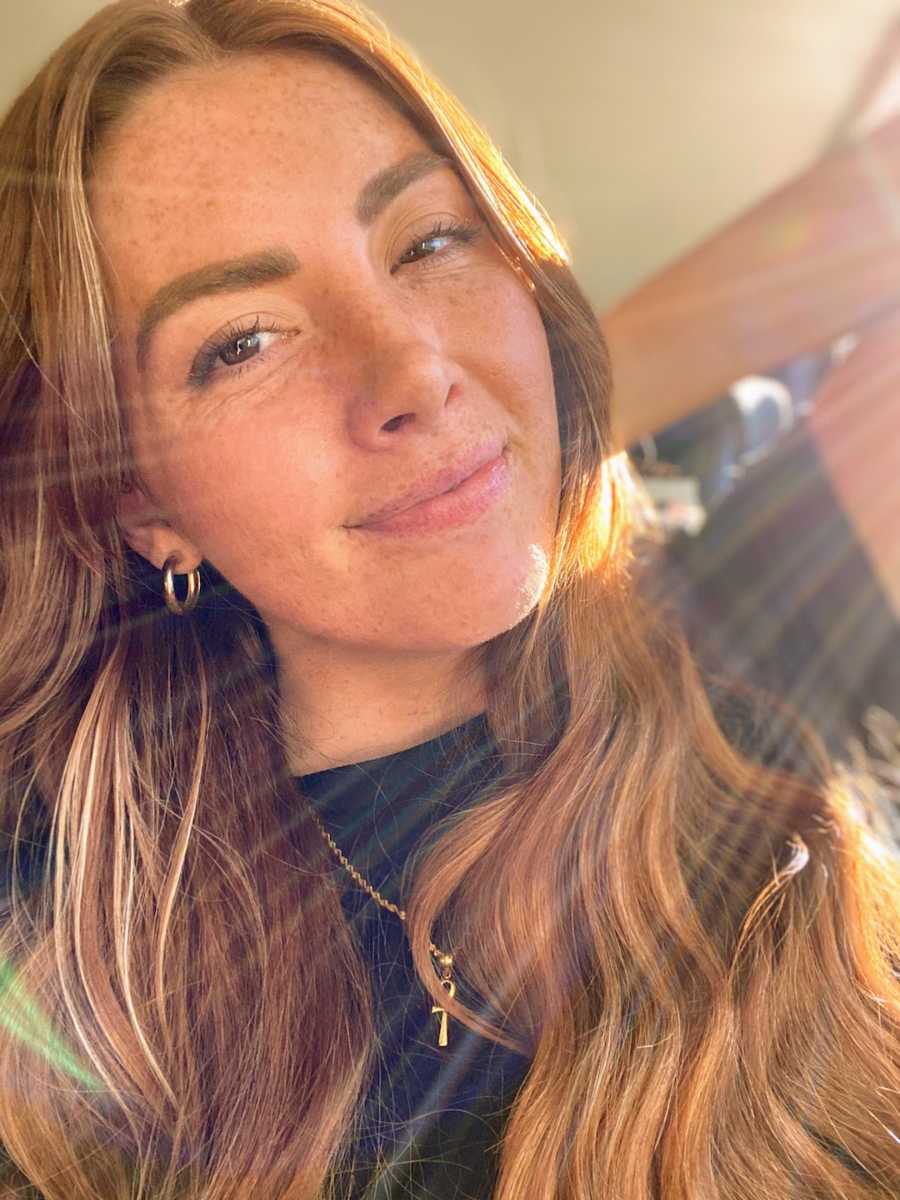 Woman taking smiling selfie in the sunlight