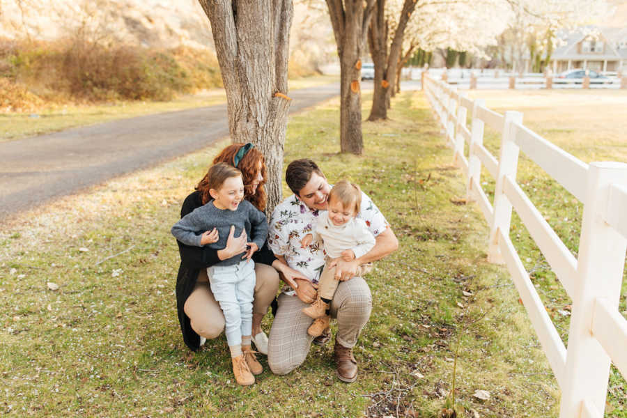 Family of four hugging each other outside