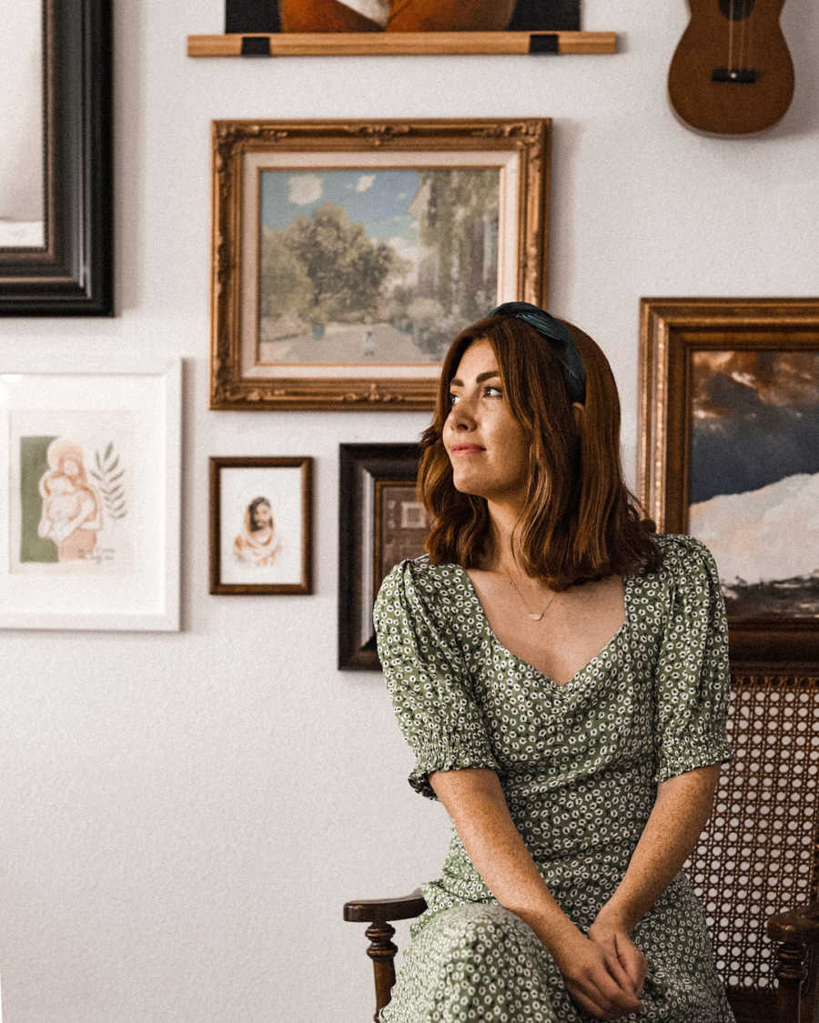 Woman in front of gallery wall looking into distance