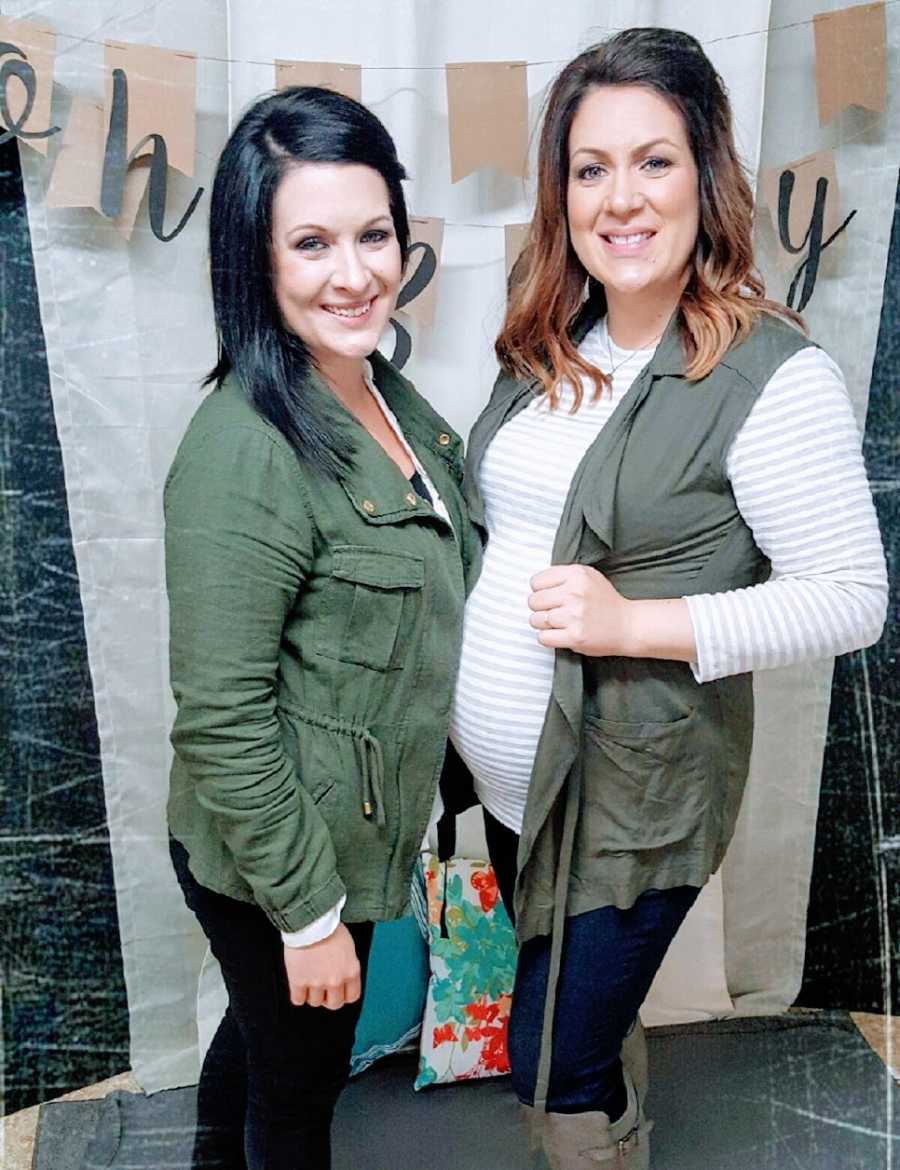 A pair of women stand together at a baby shower