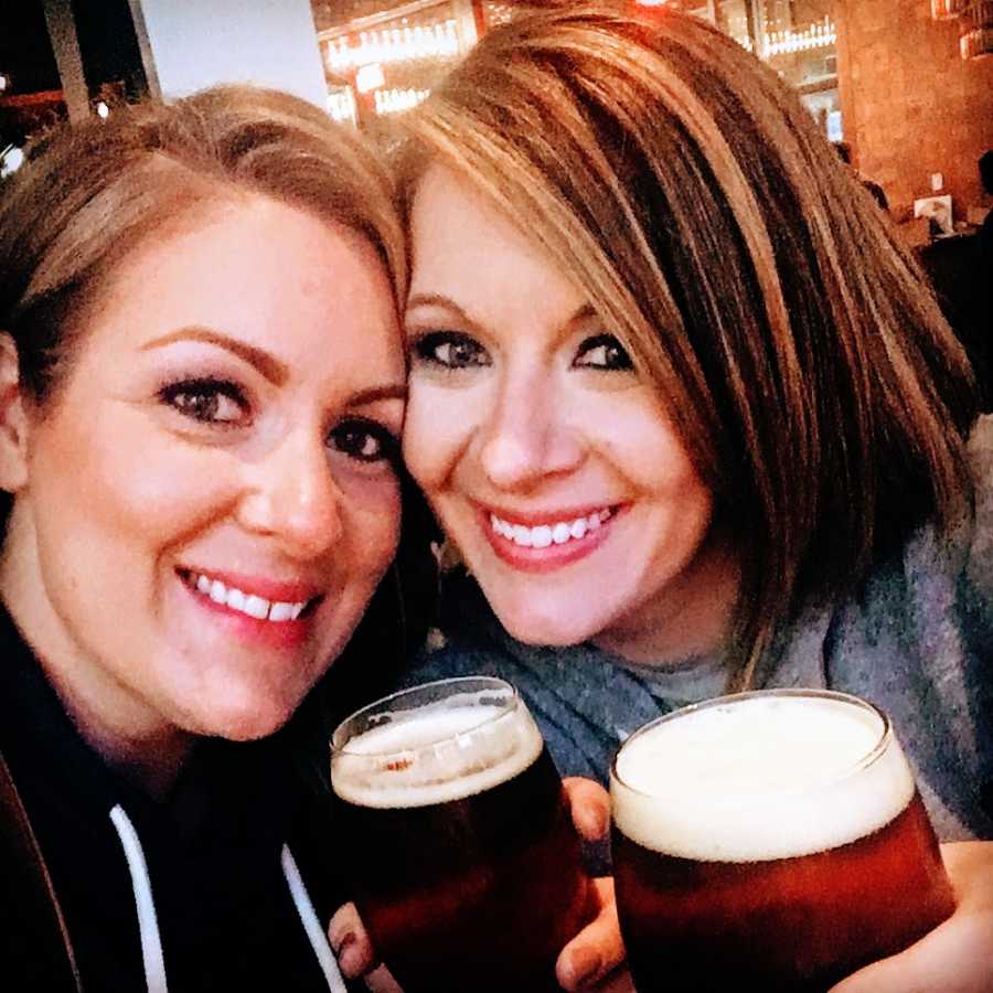 Two women drink beers together