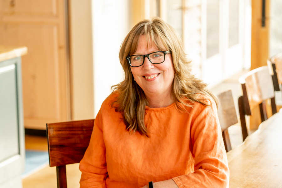 Woman wearing orange shirt smiling