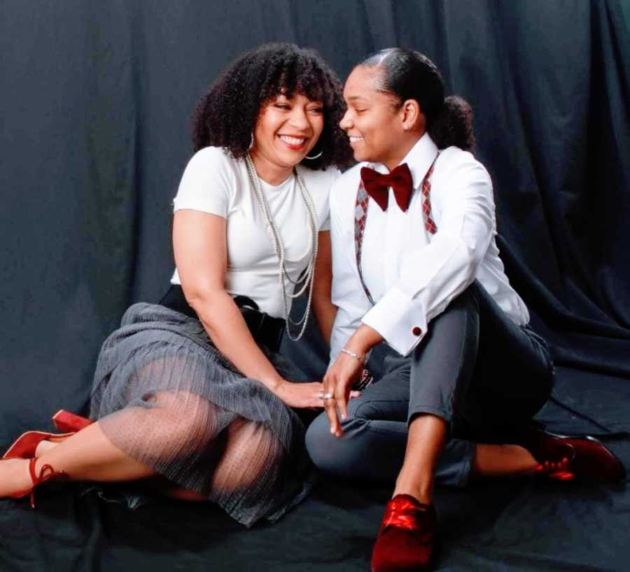 A woman and her wife dressed up against a black background