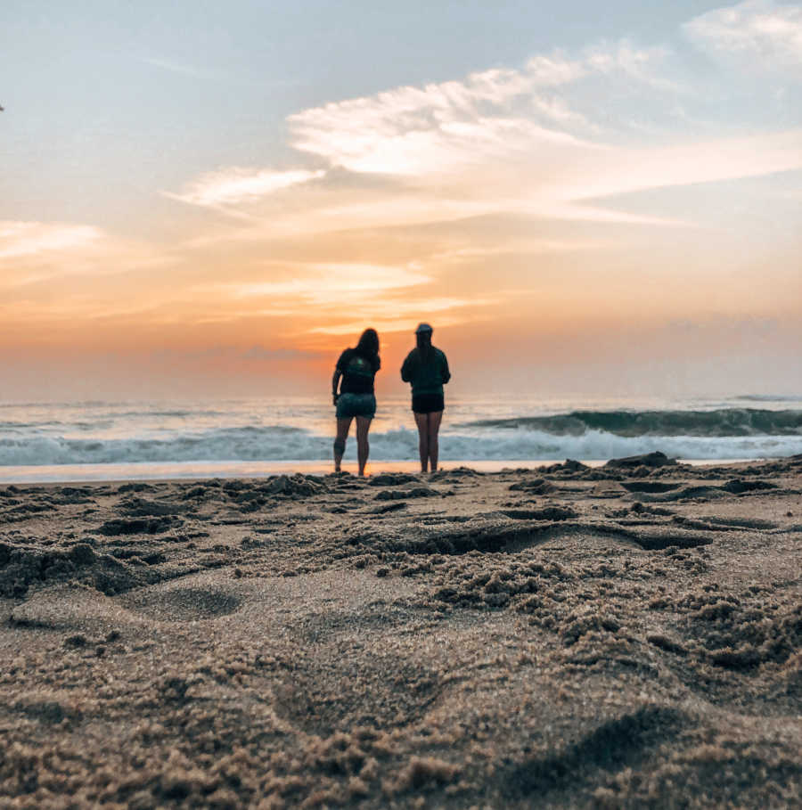 Mom and daughter on the beach at sunset