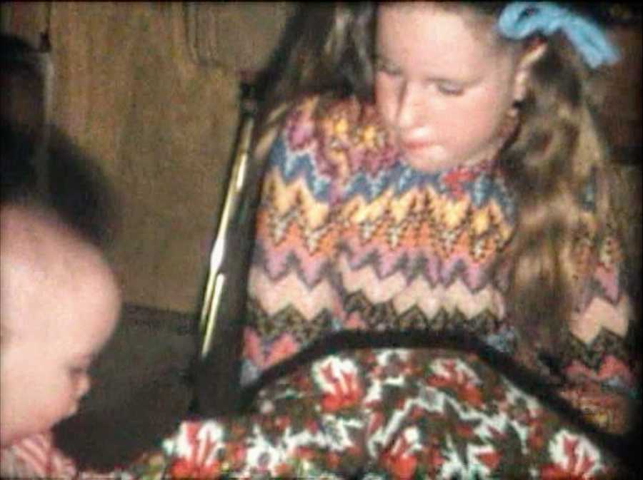 Old photo of young girl and baby boy sitting at table