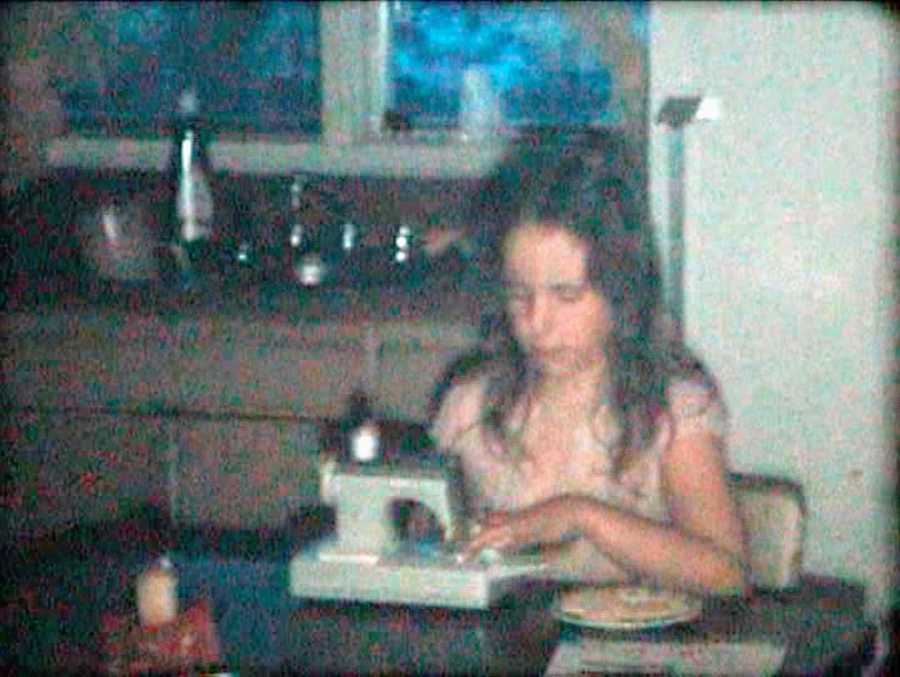 Old photo of young girl using sewing machine