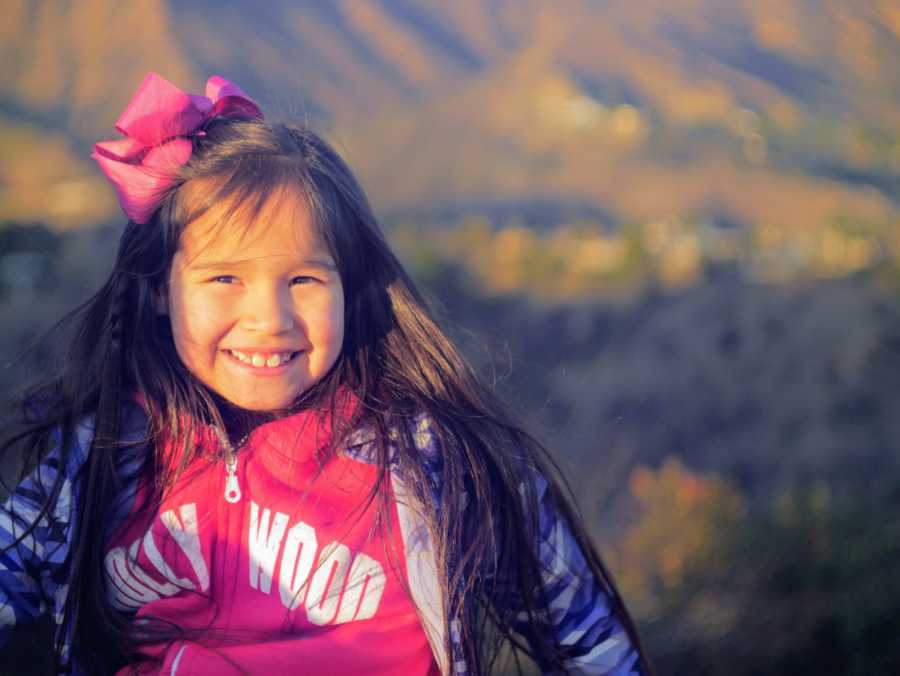 Young girl with flower in her hair smiling 