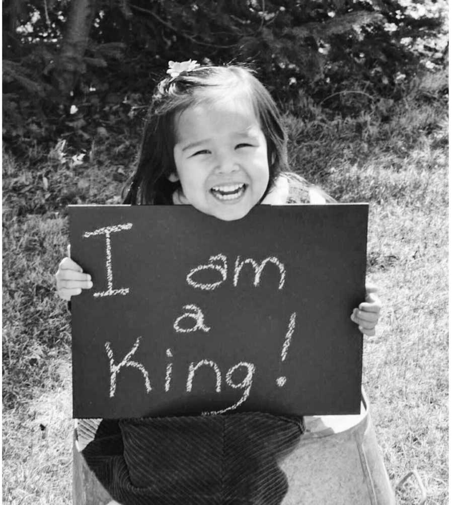Young girl holding adoption sign