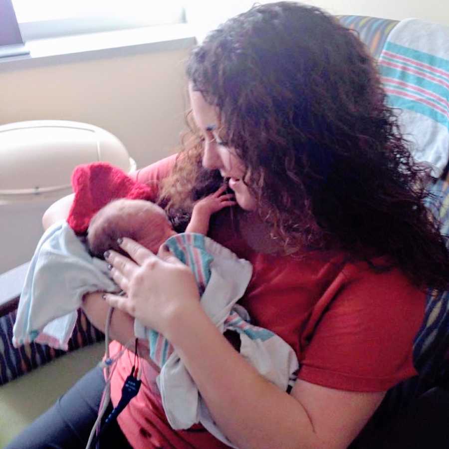 A woman holds her newborn nephew in a hospital room