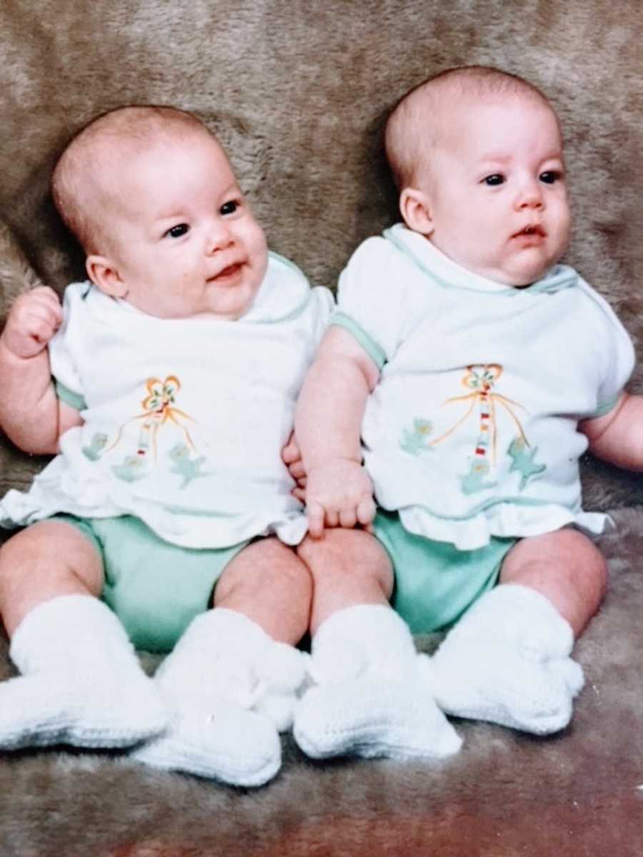 Twin baby girls wear matching blue and teal outfits