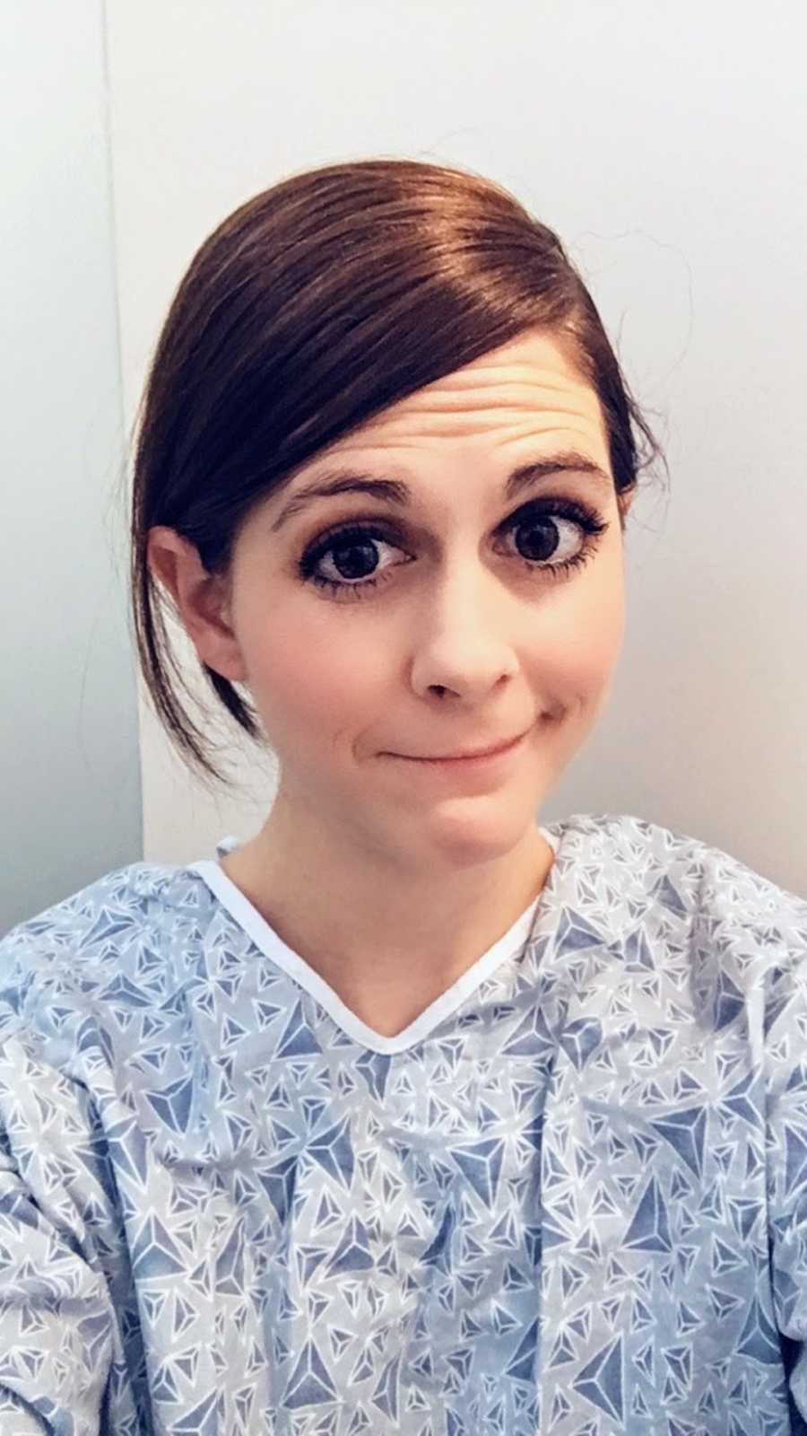 Woman in hospital gown taking selfie