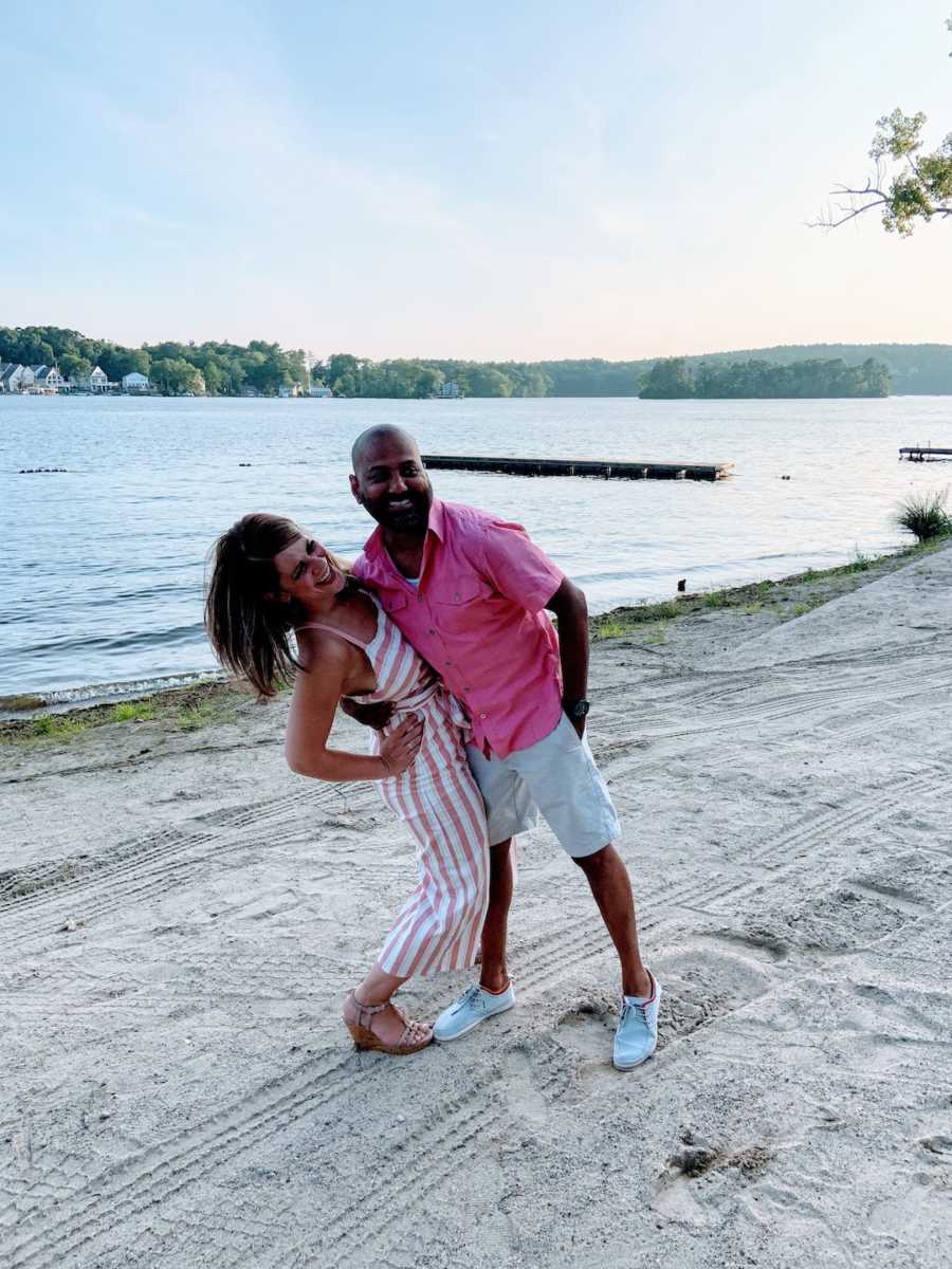 Man and woman with arms around each other taking picture at the beach