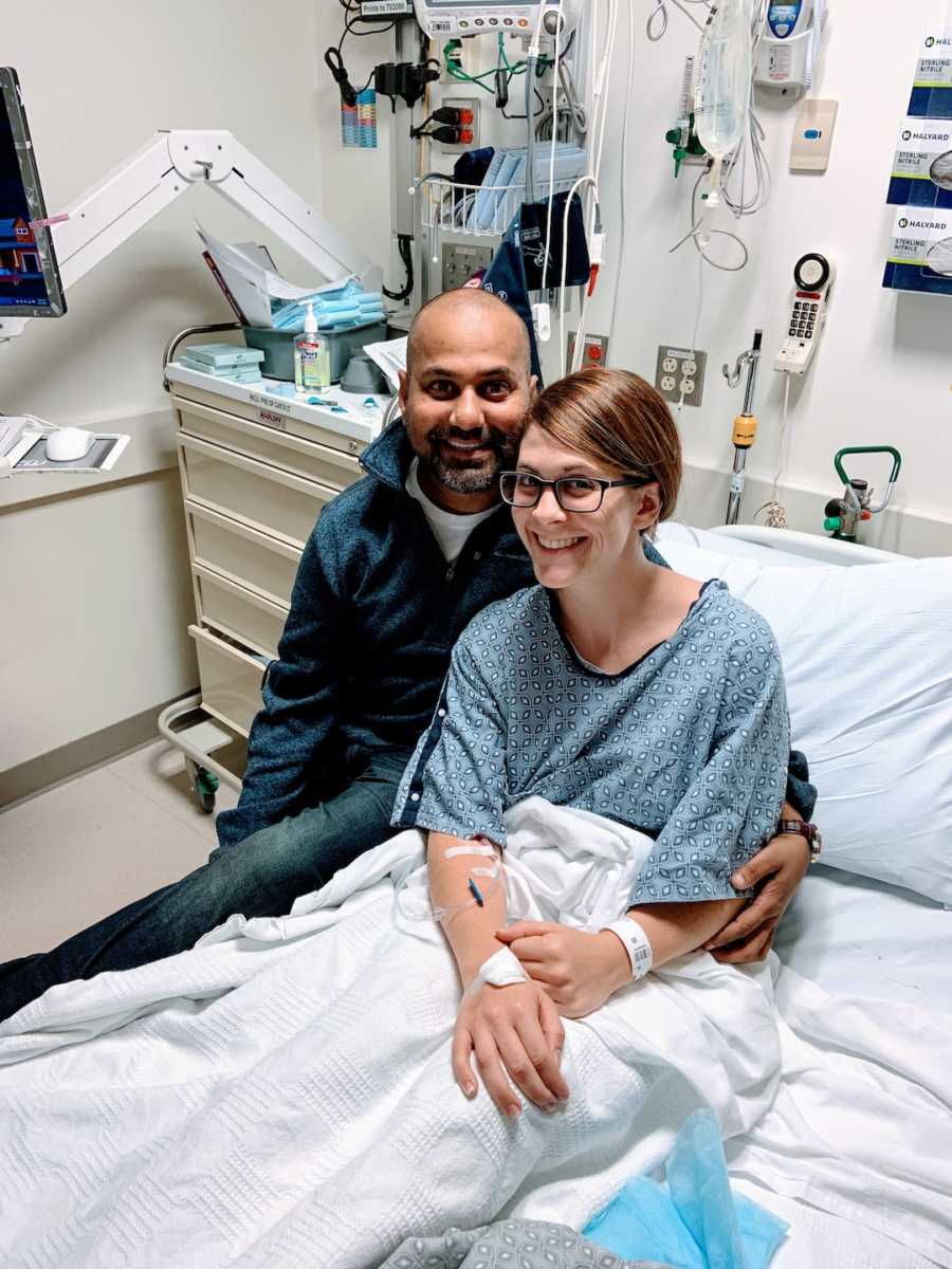 Woman in hospital bed sitting with man