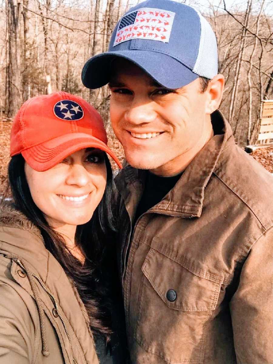 A woman and her husband wearing ballcaps and brown jackets