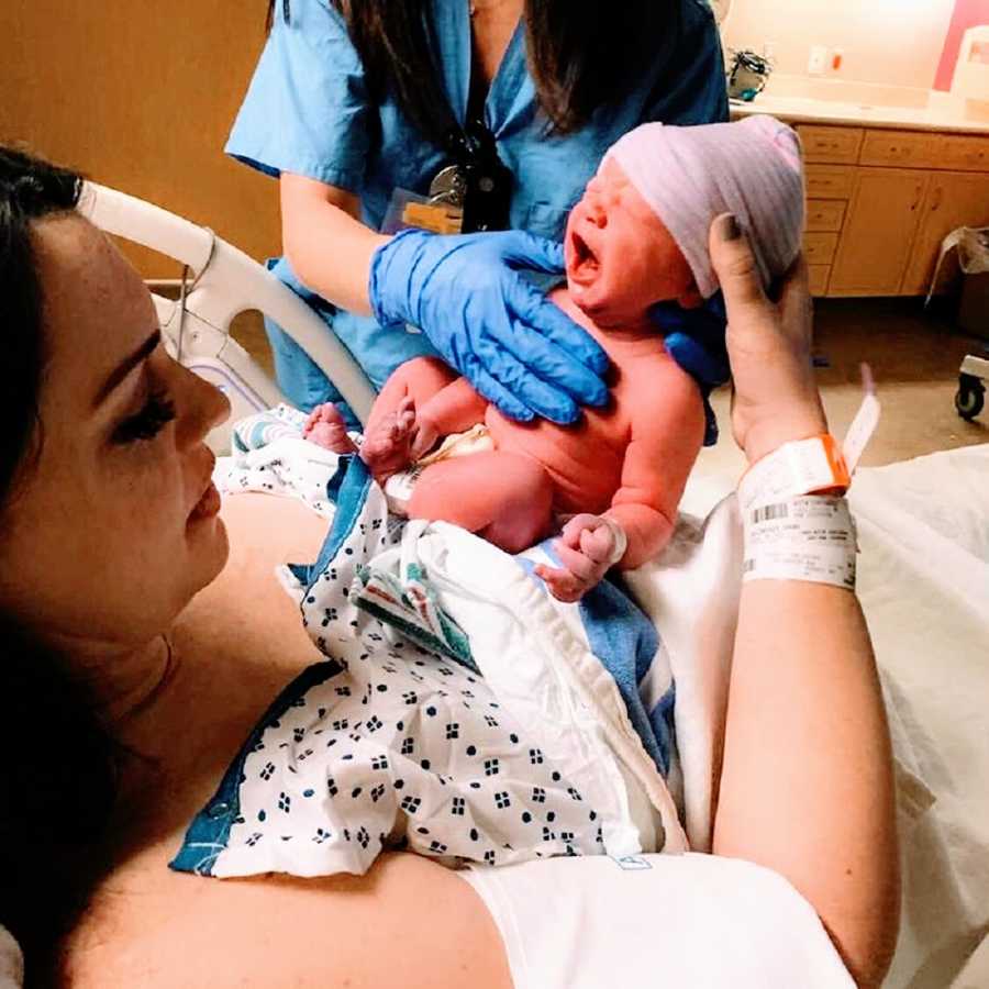 A widow holds her newborn son in the hospital