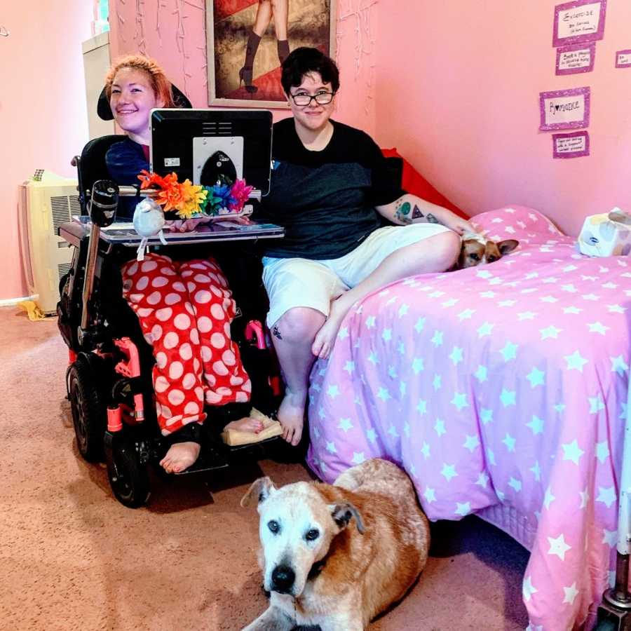 A woman with cerebral palsy and her girlfriend sit next to each other