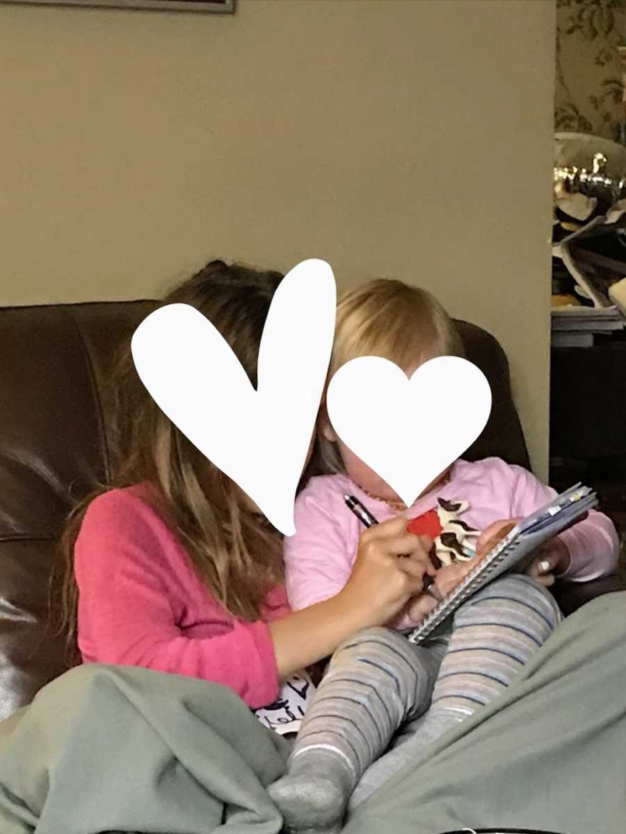 Foster siblings sitting on couch doing homework