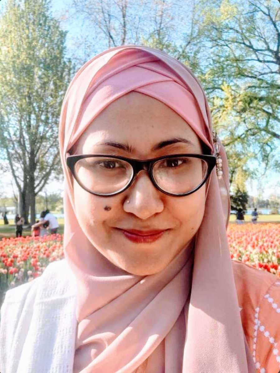 A neurodivergent mother wearing glasses and a hijab