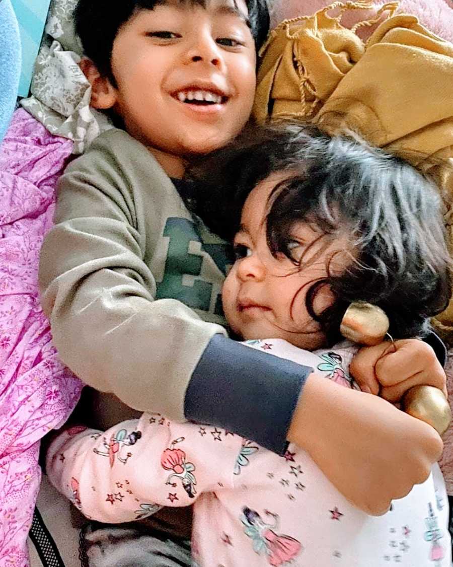 An autistic boy holds his little sister