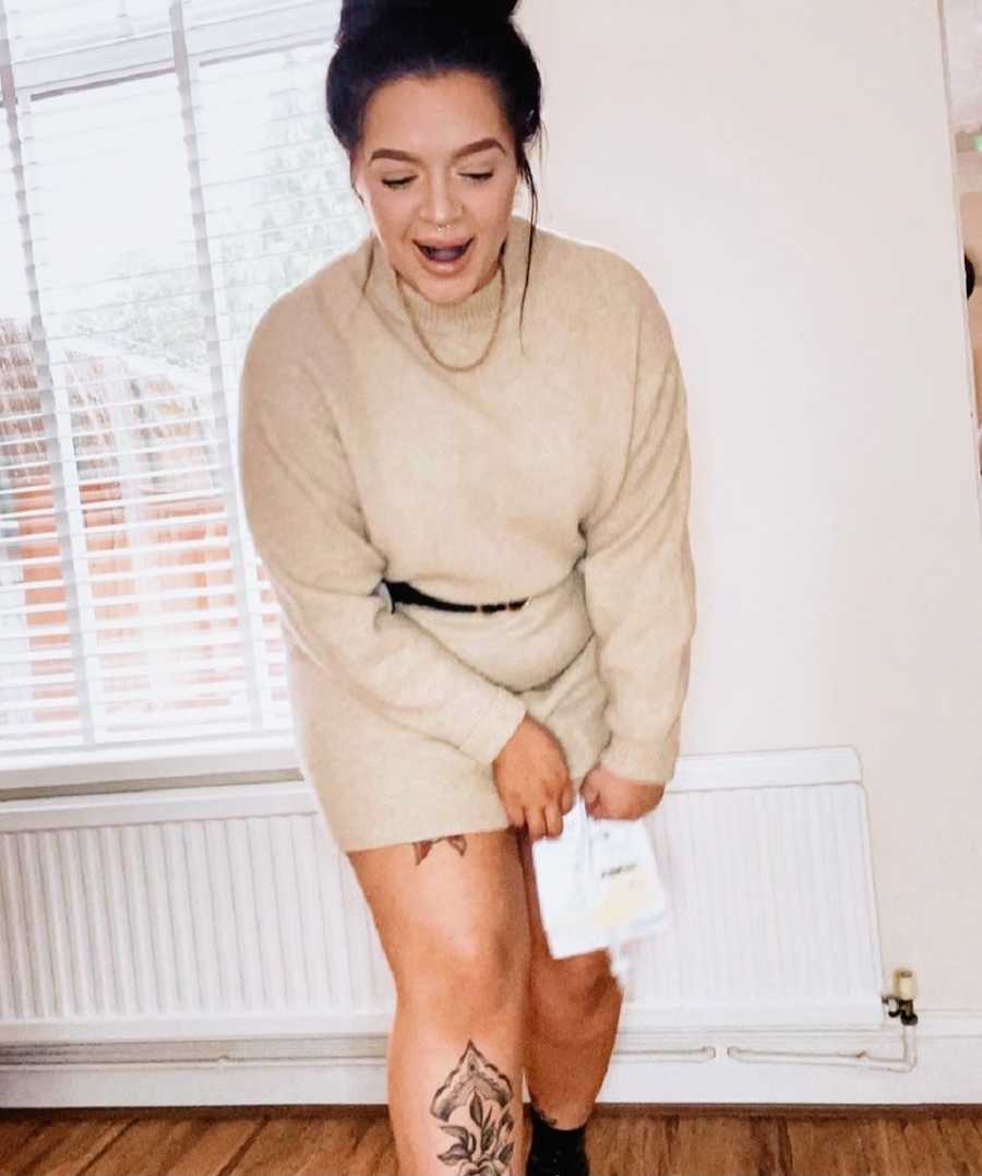 A woman with a catheter holds it while fixing her dress