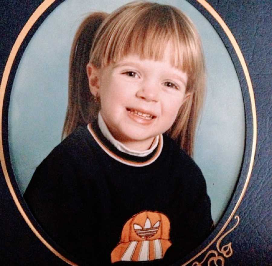 A young girl in a sweater for her school photo