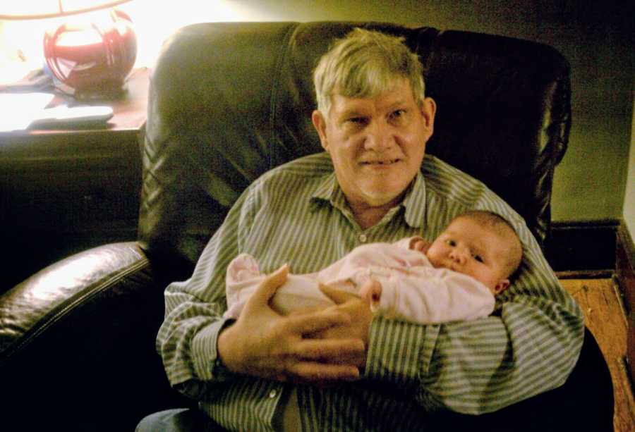 Uncle holding niece in leather chair