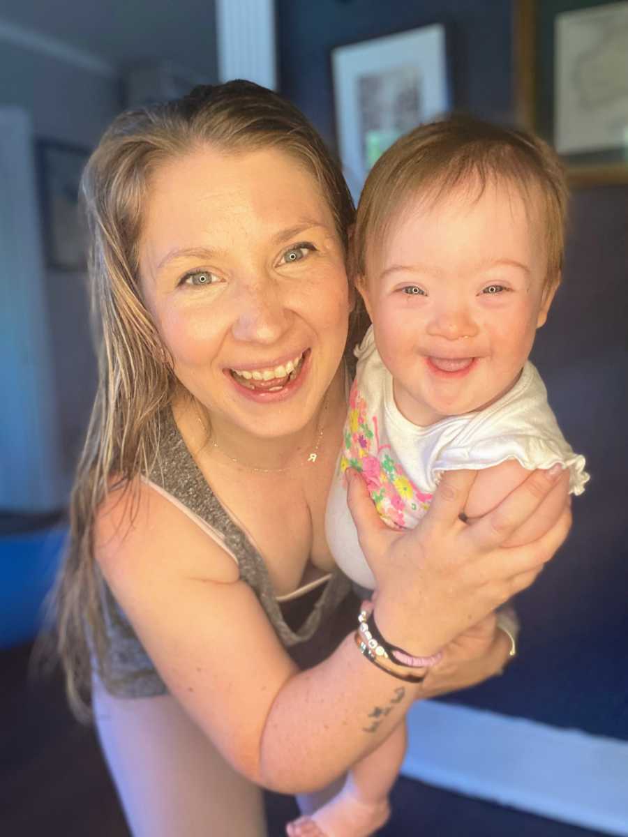Mom holding laughing and smiling daughter